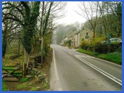 On the left the high stile and, further along the road, the Chequers Inn .